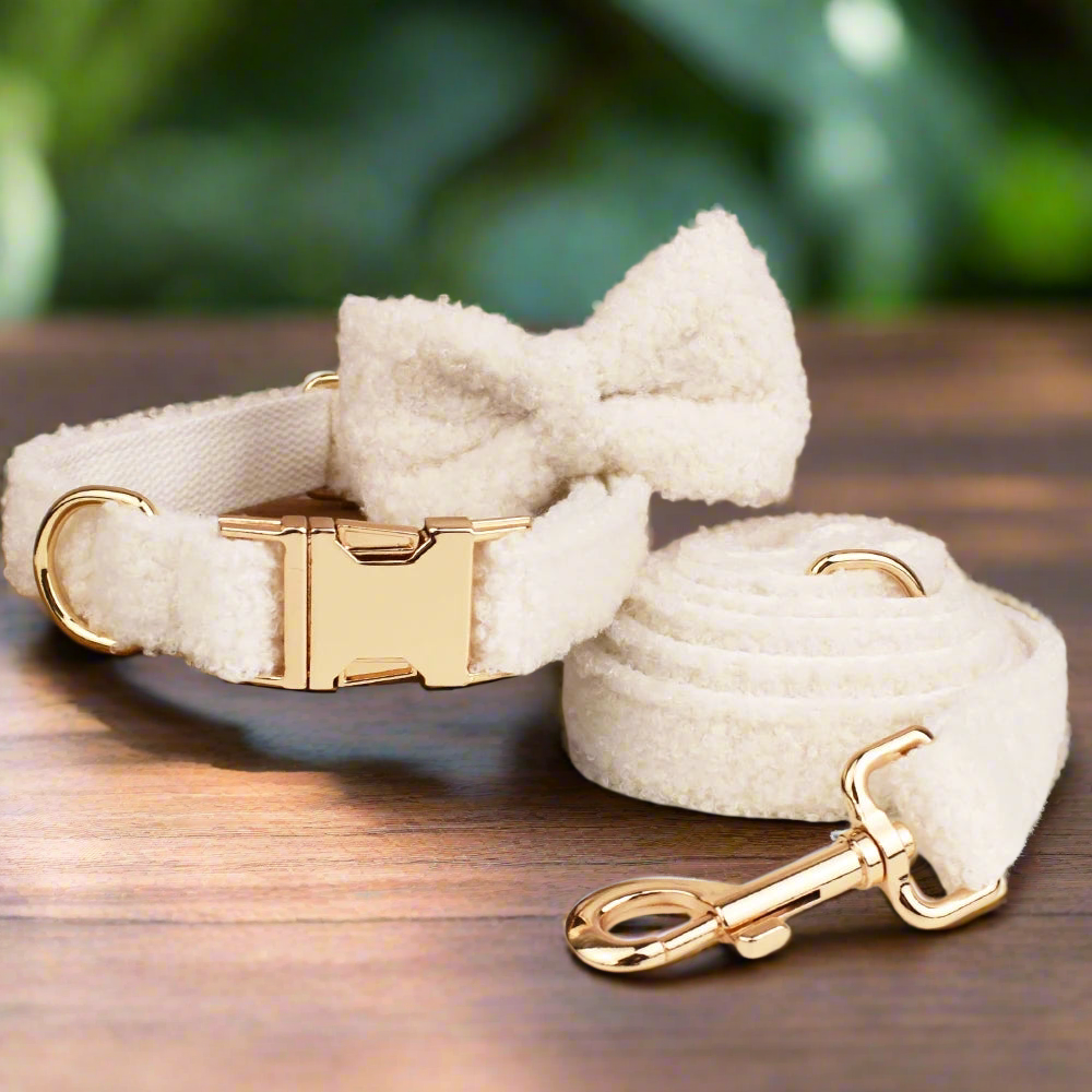 Handmade teddy fleece personalised dog collar with detachable bow tie and lead set, shown on wooden surface.