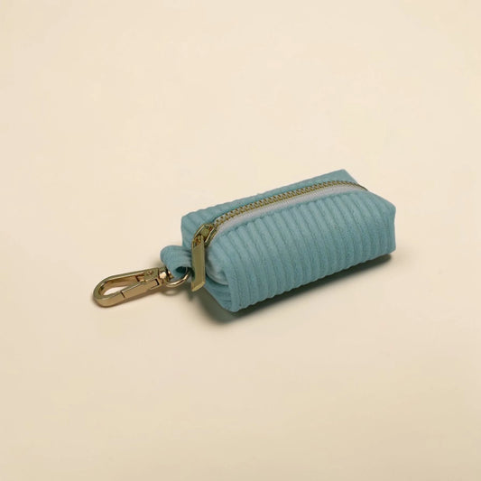 Soft mint green dog poop bag holder on a beige background