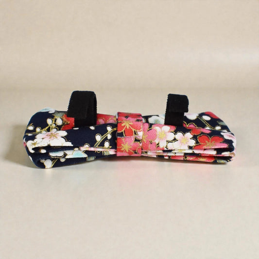 Floral-patterned dog toy with black handles on a beige background