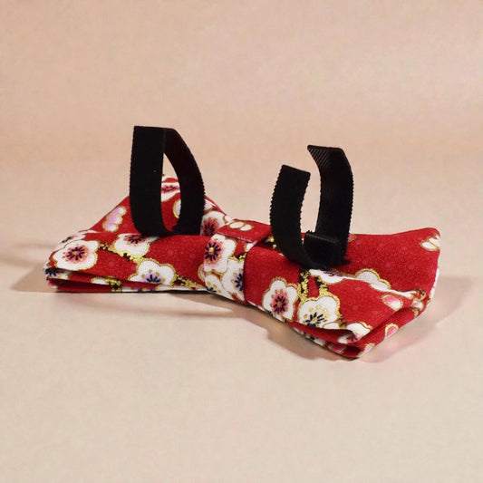 Red floral fabric with black straps on a beige background