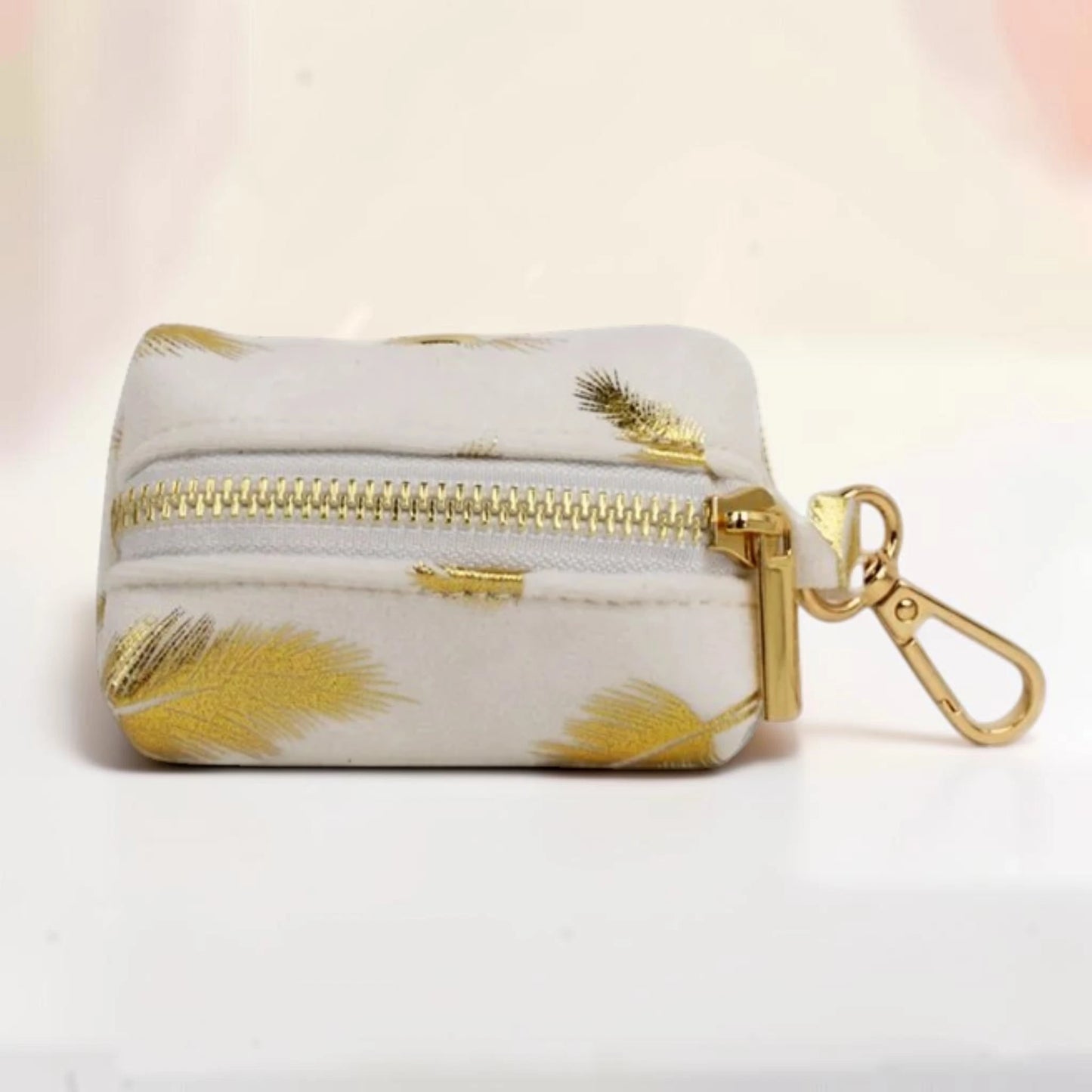 Golden feather dog poop bag holder with a gold zip and clip