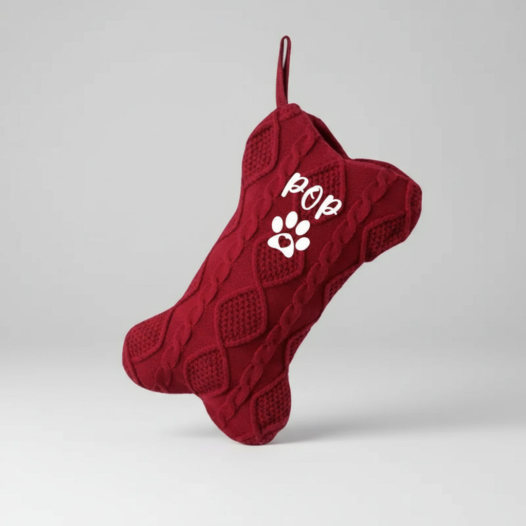 Red pet xmas stocking with paw print design on a white background