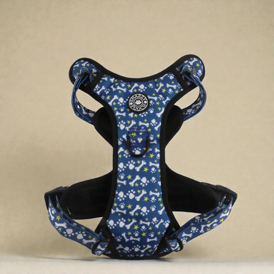 Blue dog harness with paws and bones pattern on a beige background
