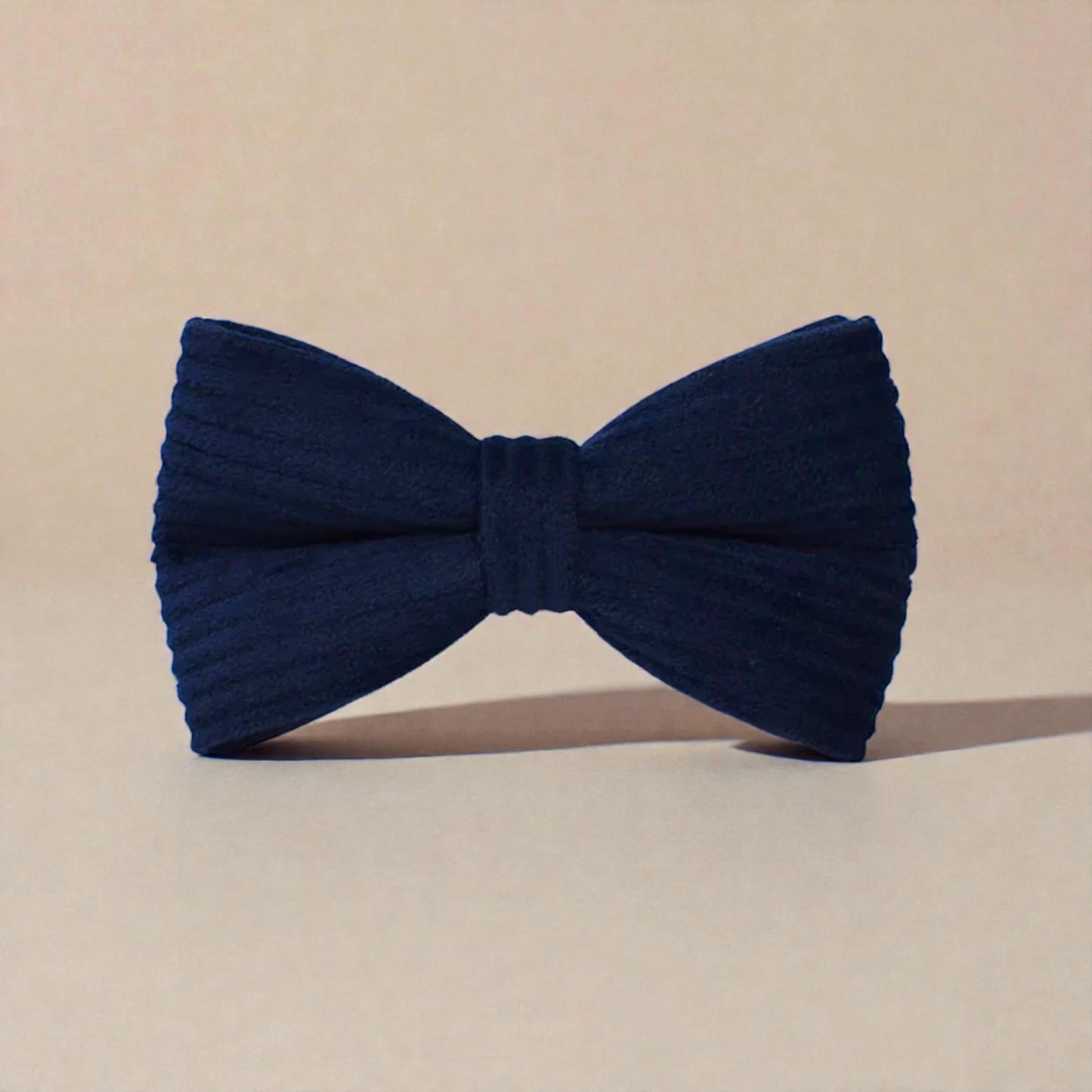 Navy blue bow tie on a beige background