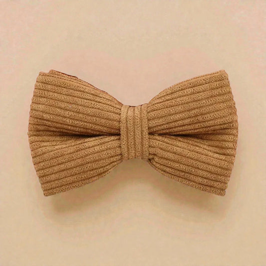 Brown corduroy bow tie on a beige background