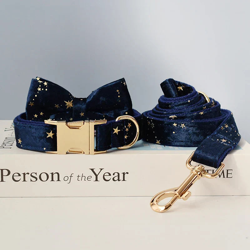 Blue velvet personalised dog collar and lead set with starry pattern, featuring a gold buckle and optional bow tie.