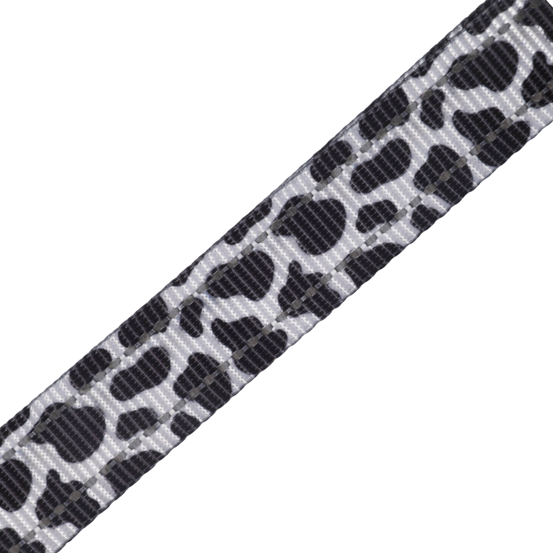 Adjustable step-in dog harness with cow print design.
