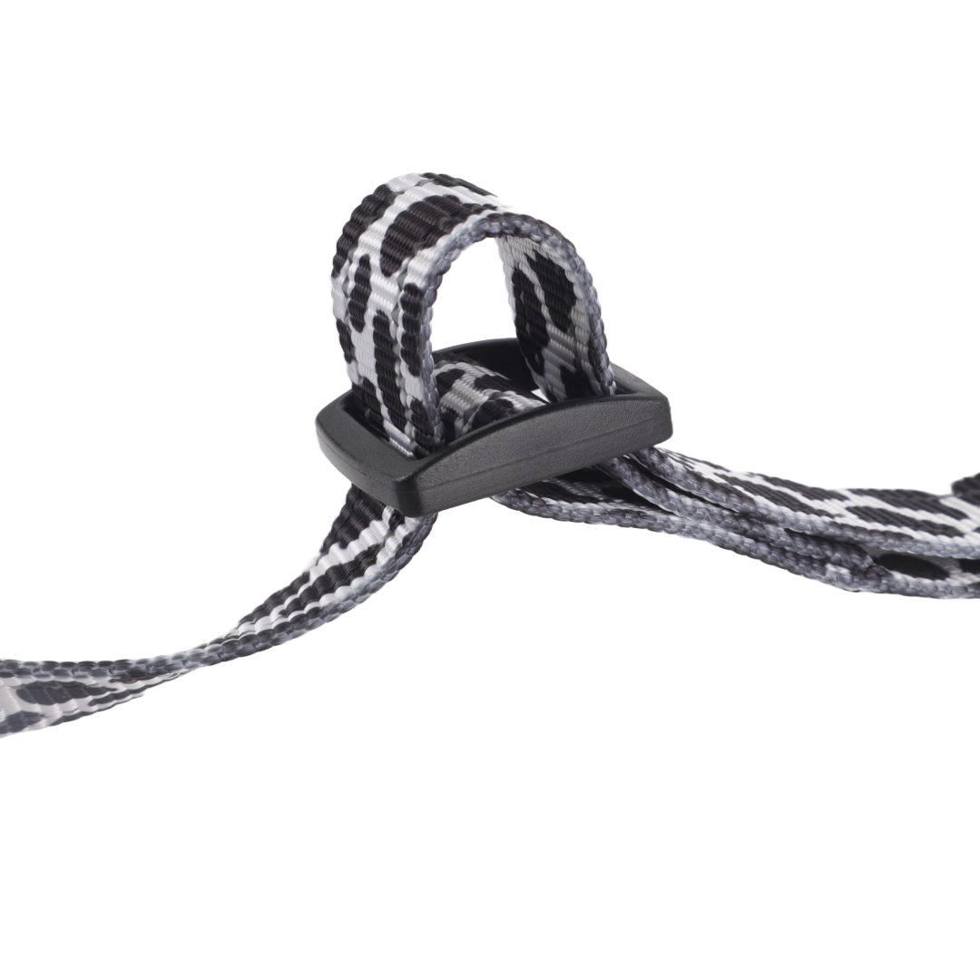 Cow print adjustable dog harness with secure double loop clasp.