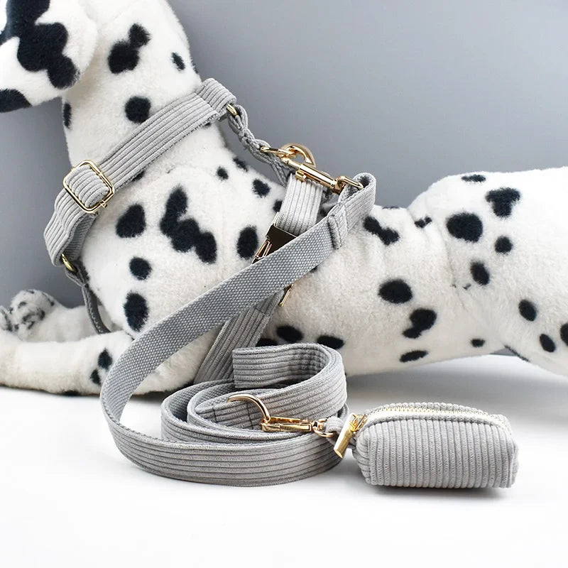 Luxury grey corduroy dog accessories, harness and leash set on plush dalmatian toy.
