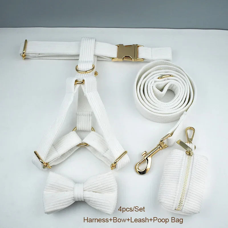 White corduroy dog collar set with harness, bow, leash, and poop bag, featuring gold hardware.