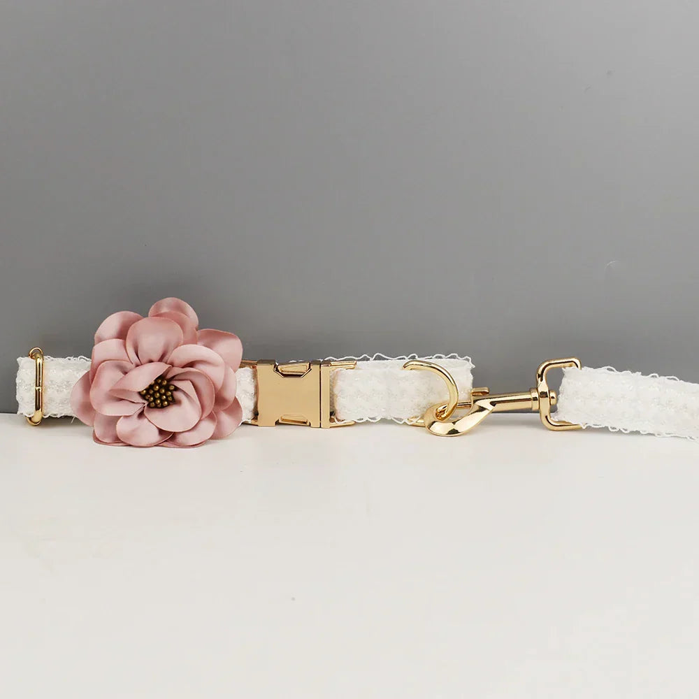 Elegant white lace dog harness with pink flower and gold-tone hardware, perfect for wedding celebrations.