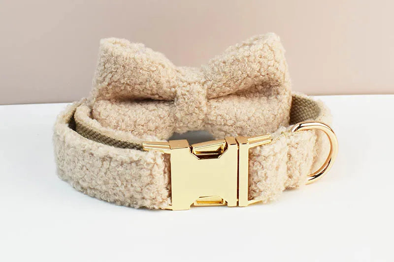 Beige handmade teddy fabric pet accessories with gold hardware and bowtie.