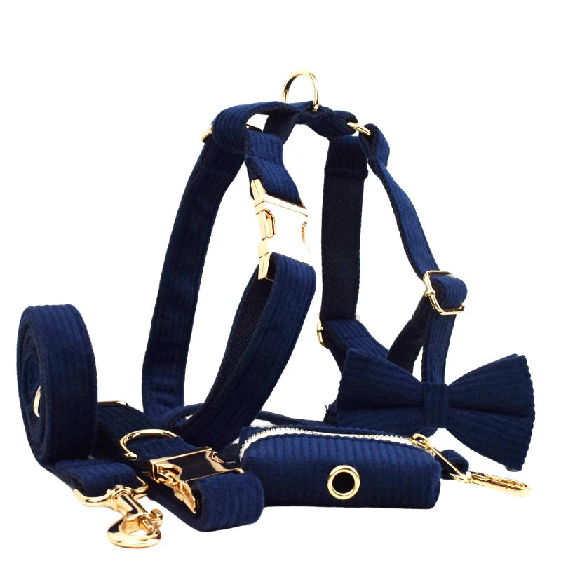 Midnight blue handmade corduroy pet accessories set, including harness, collar, lead, and bowtie with gold hardware.