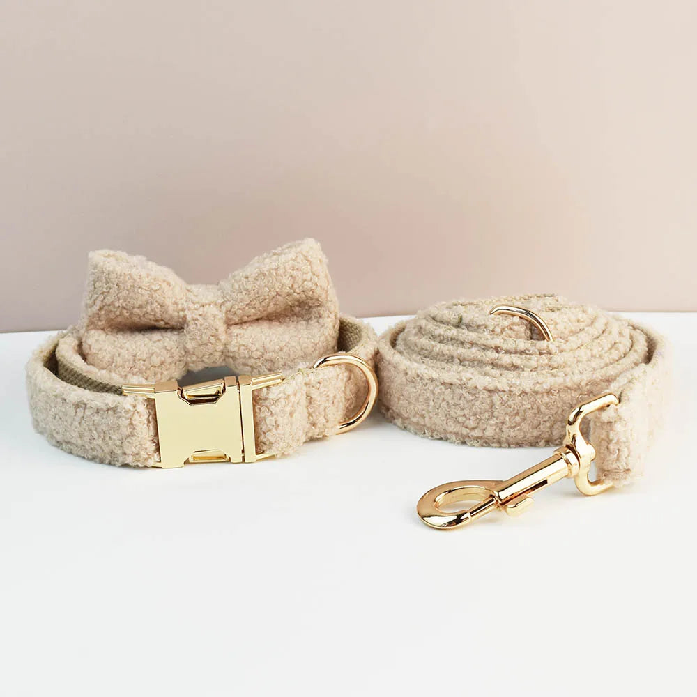 Handmade Teddy Fabric luxury pet accessories in beige, including a collar, lead, and bowtie with gold hardware.
