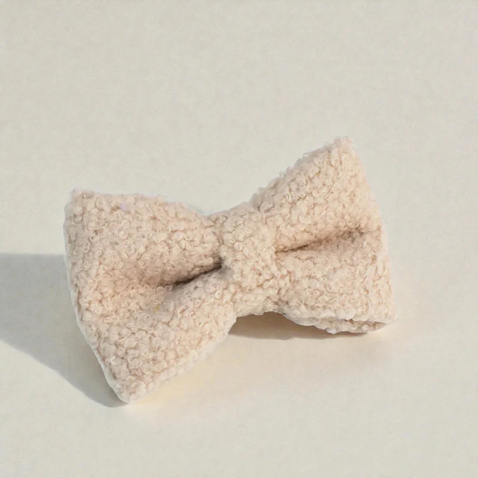 Beige bow tie on a light beige background