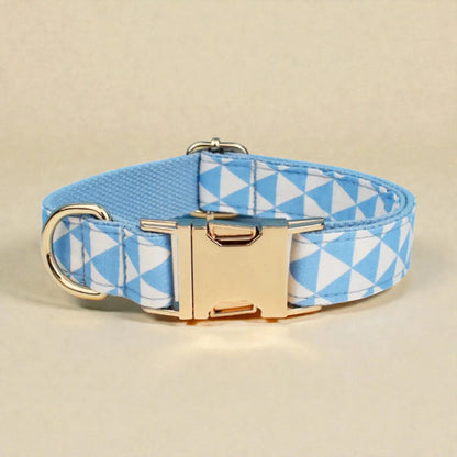 Dog collar with blue and white geometric pattern and gold buckle on beige background