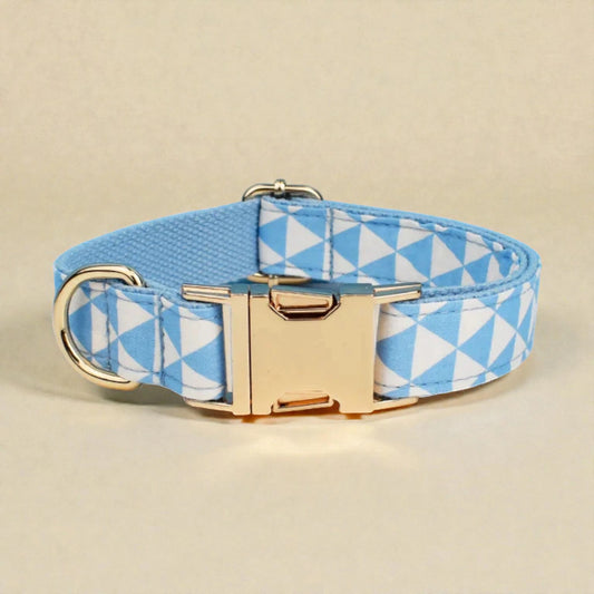 Dog collar with blue and white geometric pattern and gold buckle on beige background