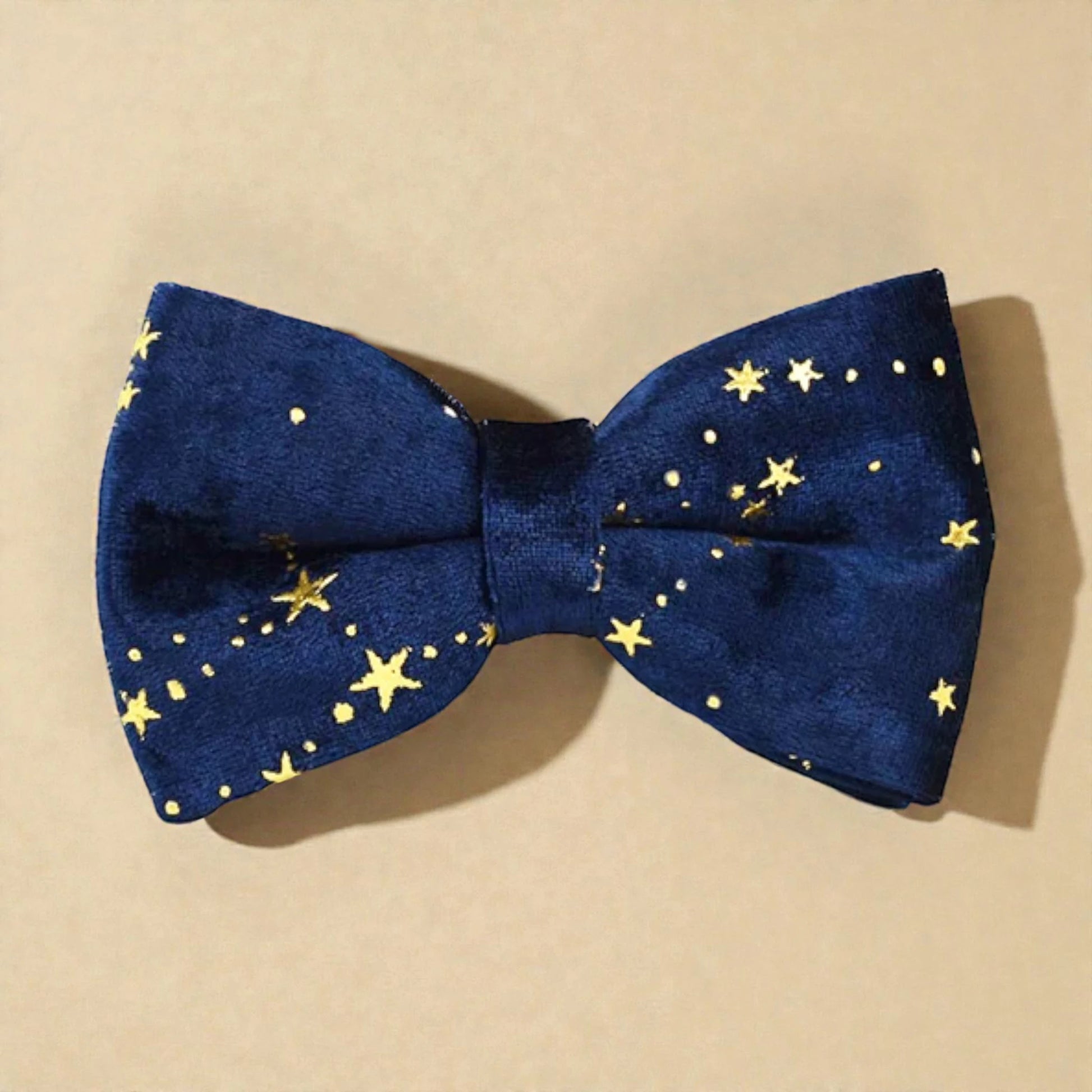 Blue bow tie with gold star pattern on a beige background