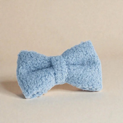 Blue textured bow object on a beige background