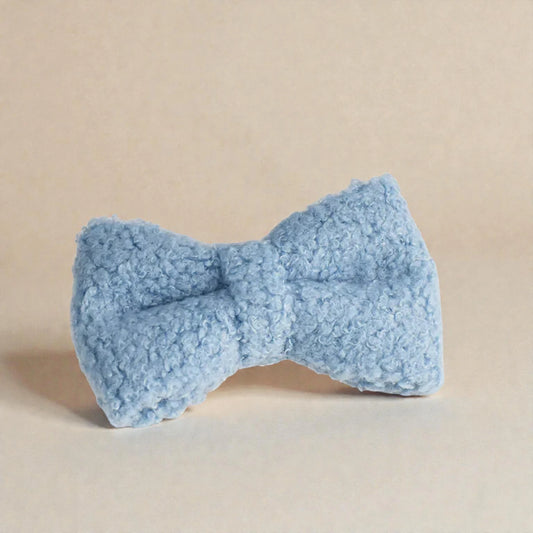 Blue textured bow object on a beige background