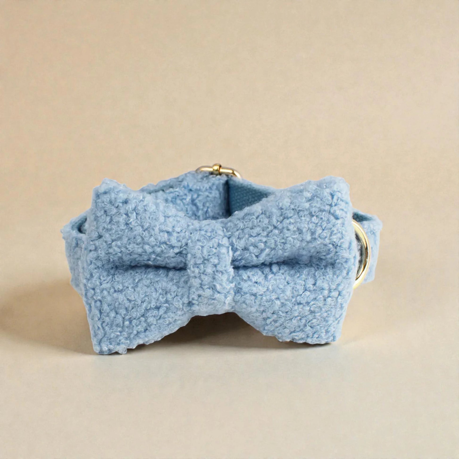 Blue fleece bow on a beige background