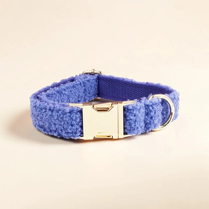 Blue teddy fleece dog collar with a gold buckle on a beige background
