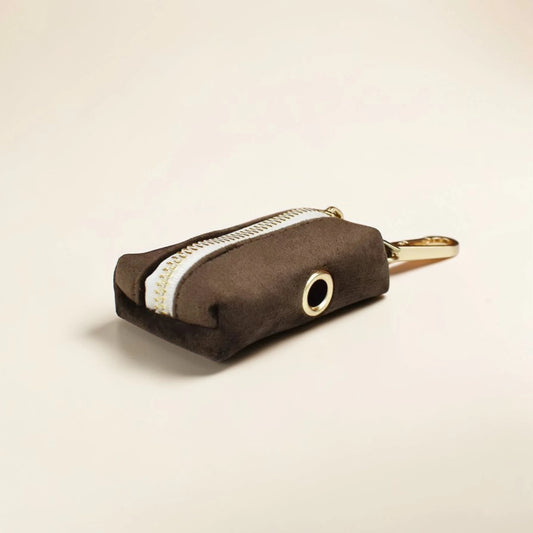 Brown dog poop bag holder with a gold zip on a beige background