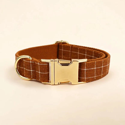 Brown plaid dog collar with a gold buckle on a beige background