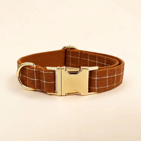 Brown plaid dog collar with a gold buckle on a beige background