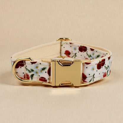 Floral-patterned red cherry dog collar with gold buckle on a beige background