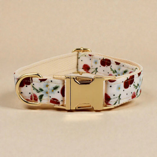 Floral-patterned red cherry dog collar with gold buckle on a beige background