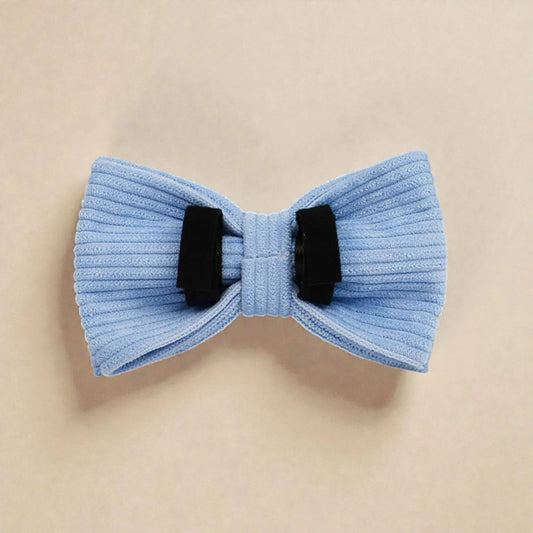 Light blue bow tie with black velcro loops on a beige background