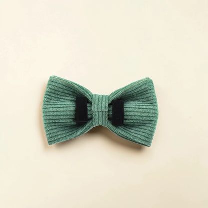 Green detachable dog bow on a beige background