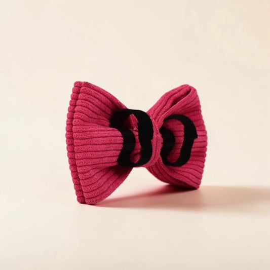 Pink detachable corduroy dog bow on a beige background