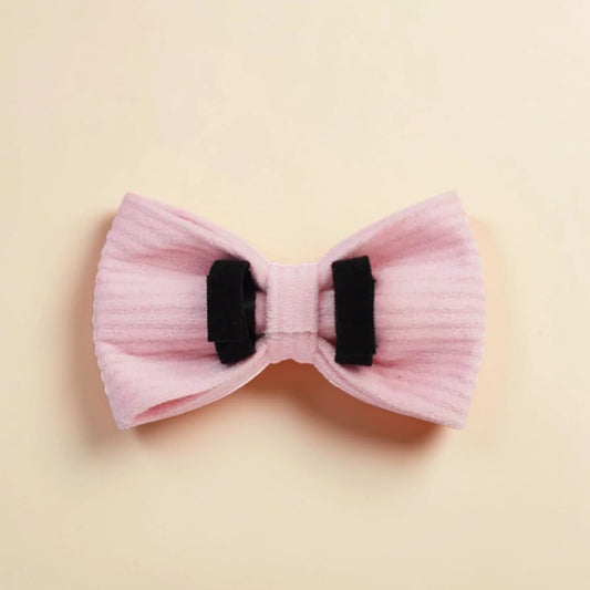 Pink detachable dog bow on a beige background