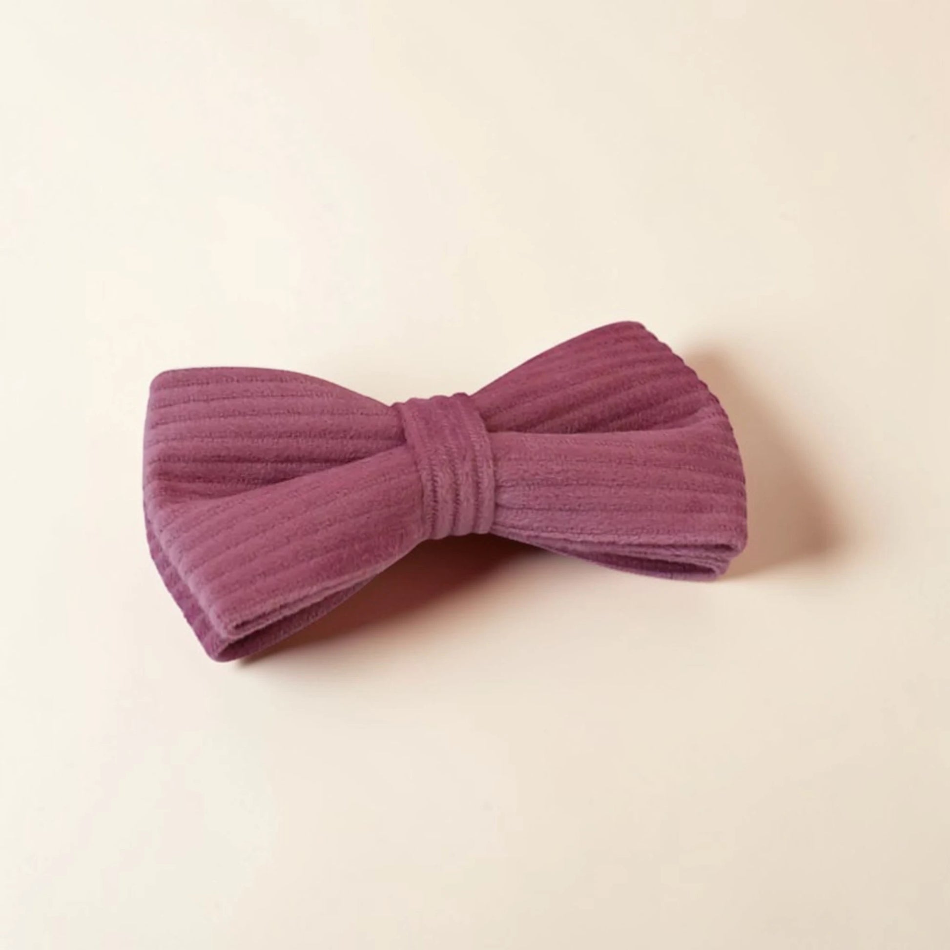 Powder pink dog bow on a beige background