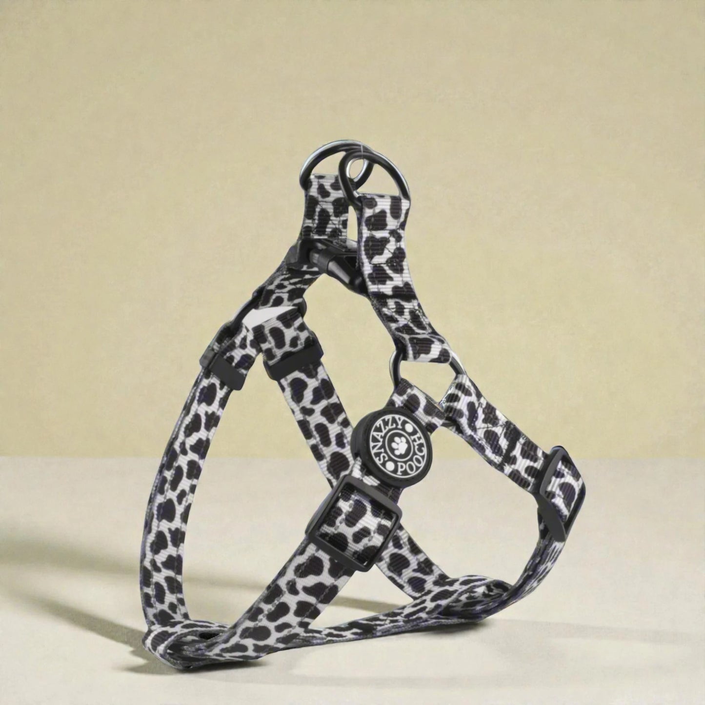 Cow print dog harness on a beige background