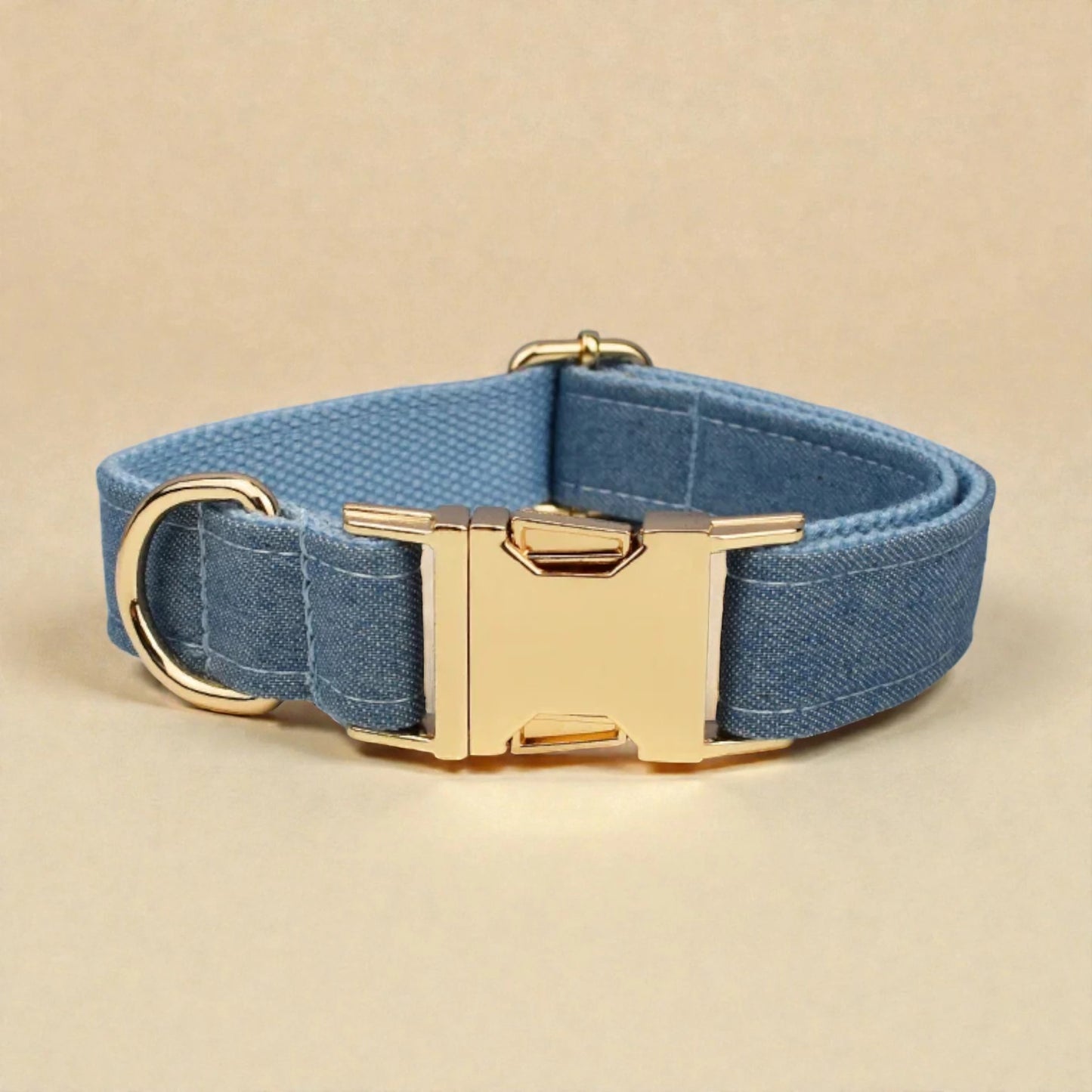 Blue dog collar with a gold buckle on a beige background