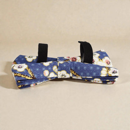 Floral-patterned blue bow tie on a beige background