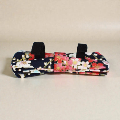 Floral-patterned dog toy with black handles on a beige background