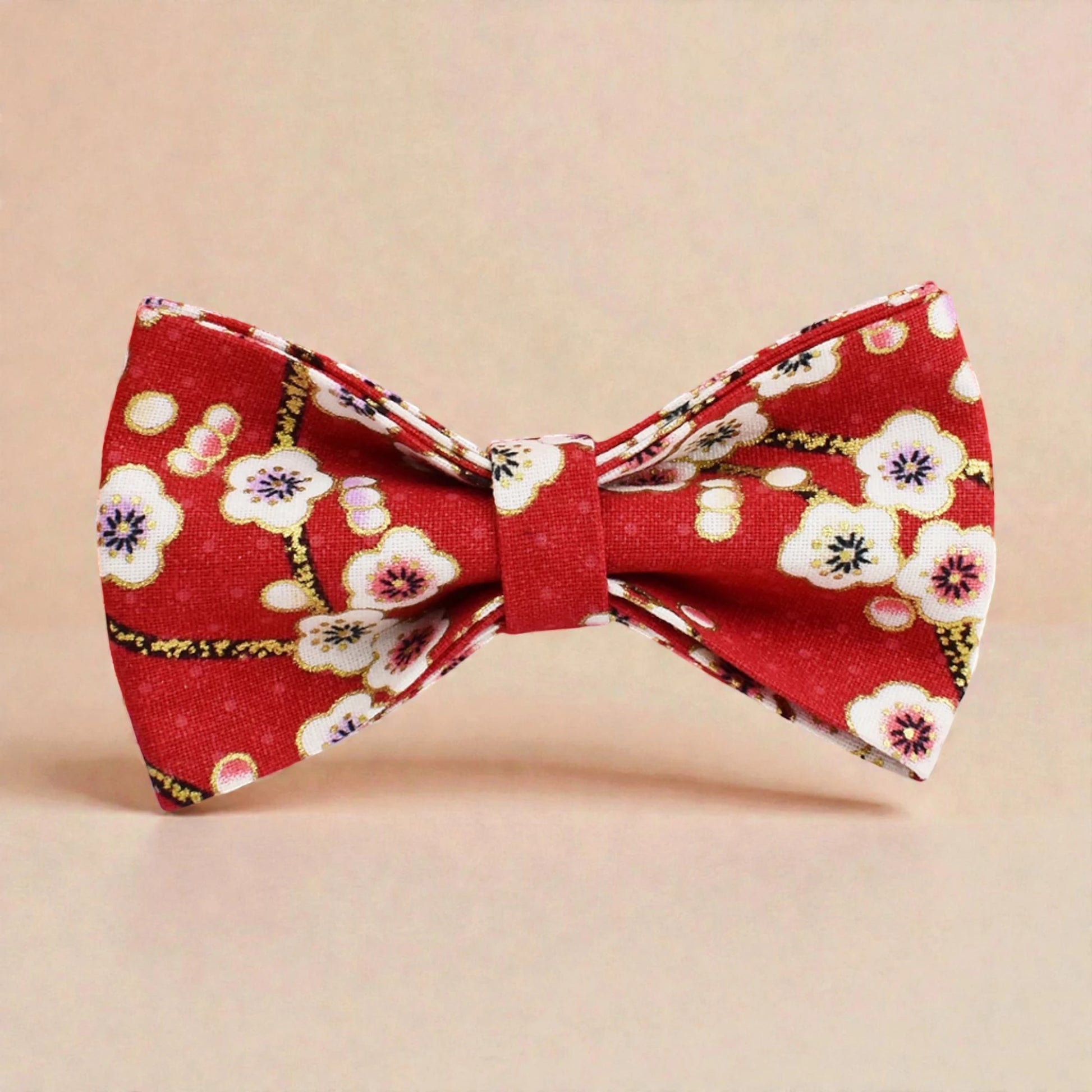 Red floral bow tie on a beige background