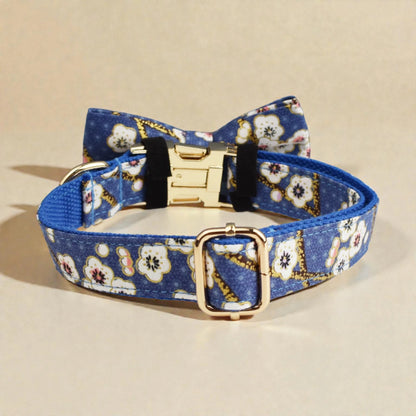 Blue floral-patterned dog collar with gold buckle on a beige background