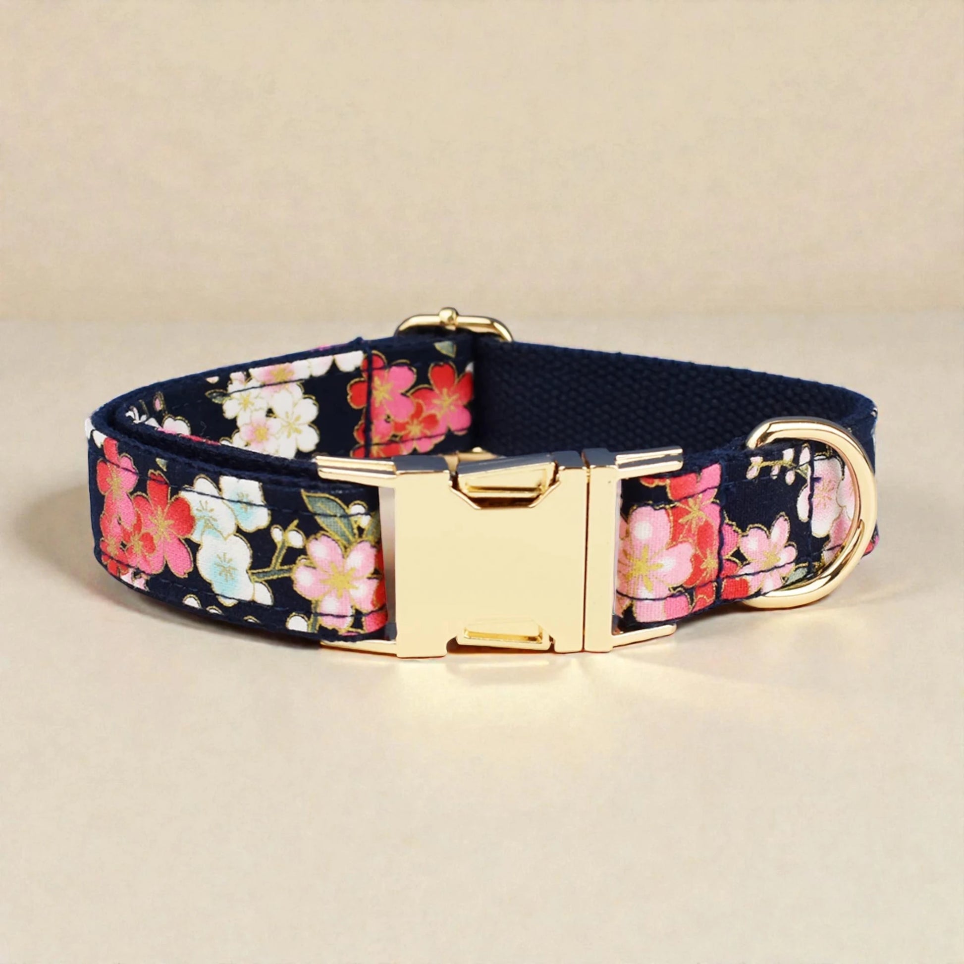 Floral-patterned dog collar with a gold buckle on a beige background