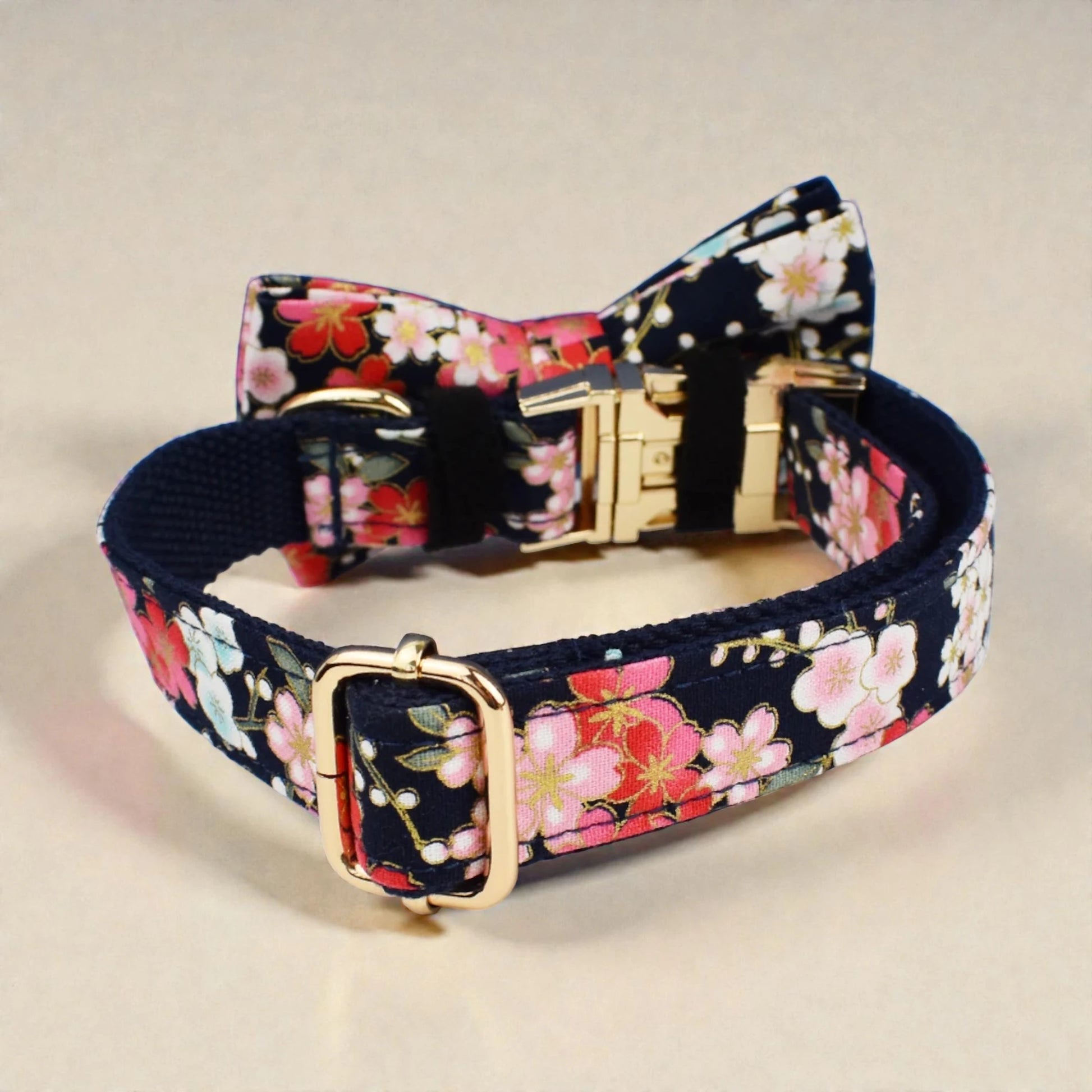 Navy floral dog collar with a colorful bow on a beige background
