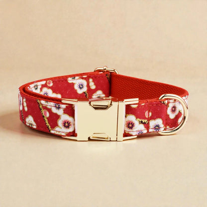 Red floral dog collar with gold buckle on a beige background