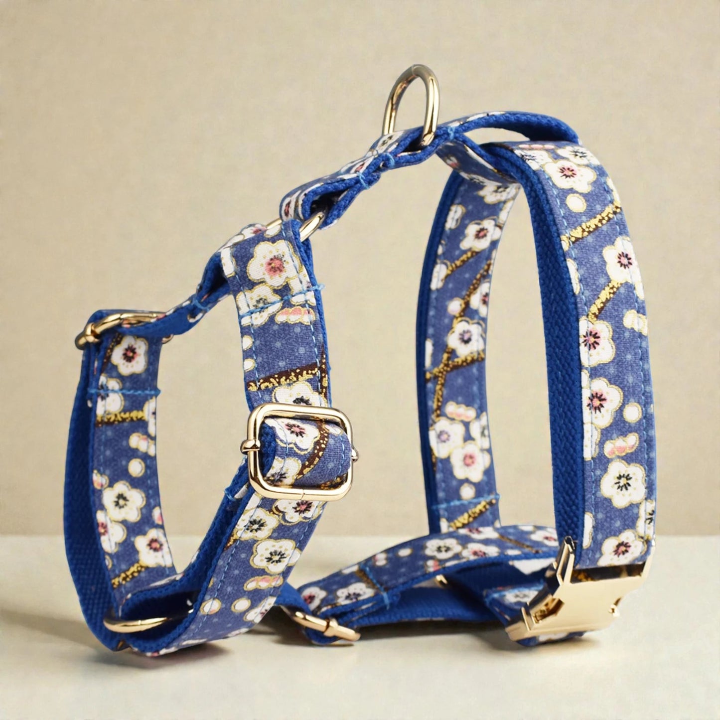 Blue floral-patterned dog harness on a beige background