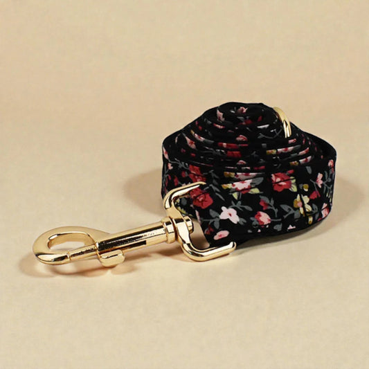 Floral-patterned dog leash with gold clasp on a beige background