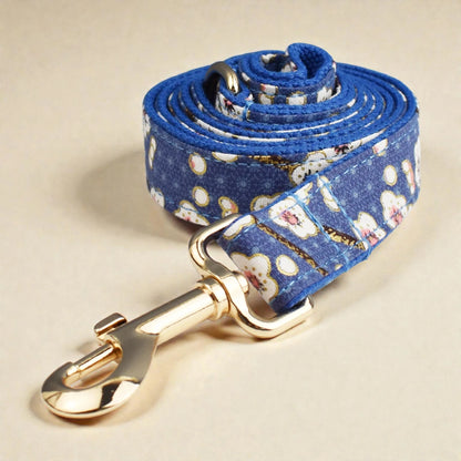 Floral-patterned dog leash with a gold clasp on a beige background