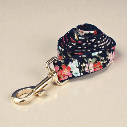 Floral patterned dog leash with a gold clip on a beige background