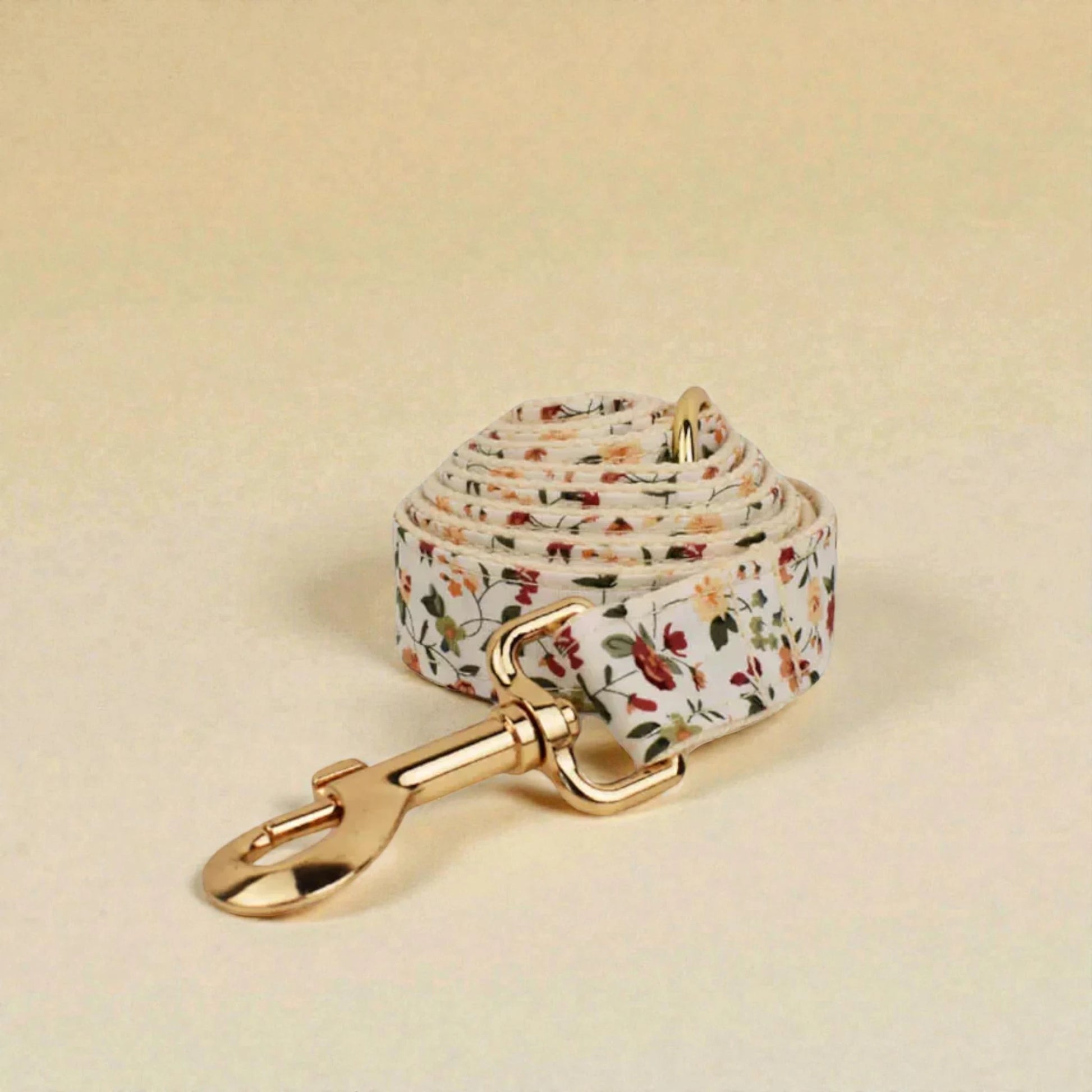 Floral-patterned dog lead with gold clip on a beige background